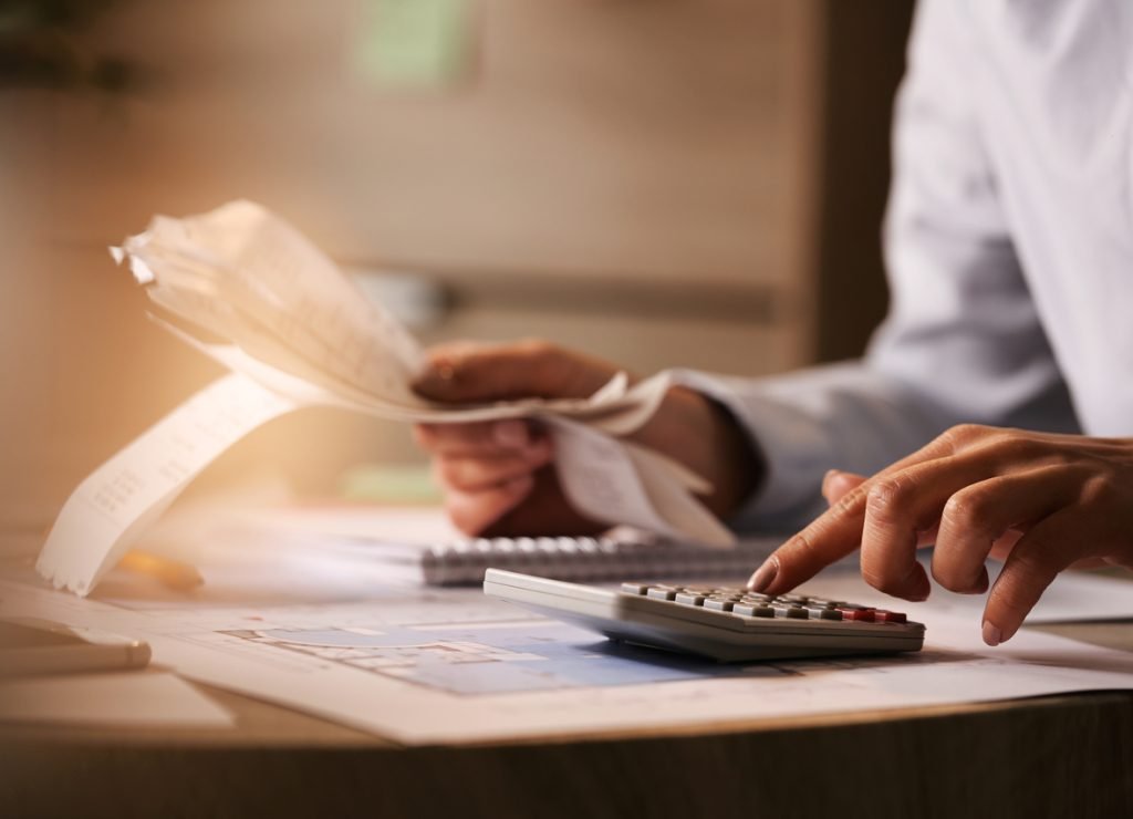 closeup-economist-using-calculator-while-going-through-bills-taxes-office_Easy-Resize.com